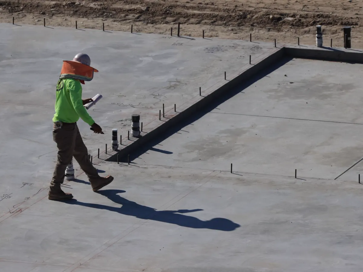 Construction professional inspecting a concrete slab