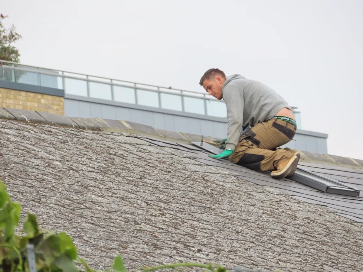 Roofing professional repairing roof tiles